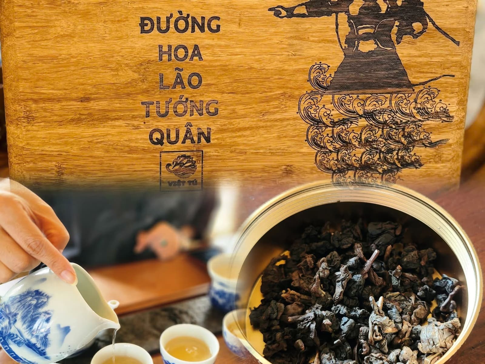 Hộp gỗ khắc tên trà và hình vị tướng, phía dưới là tay rót trà ra chén và hộp trà khô vo viên